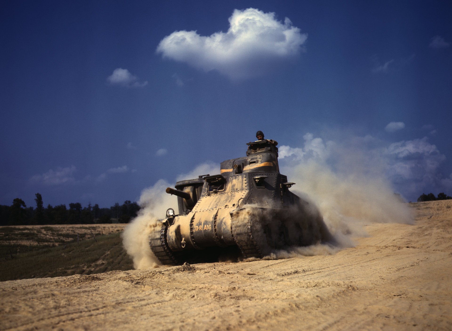Military equipment in motion. tank in the dust