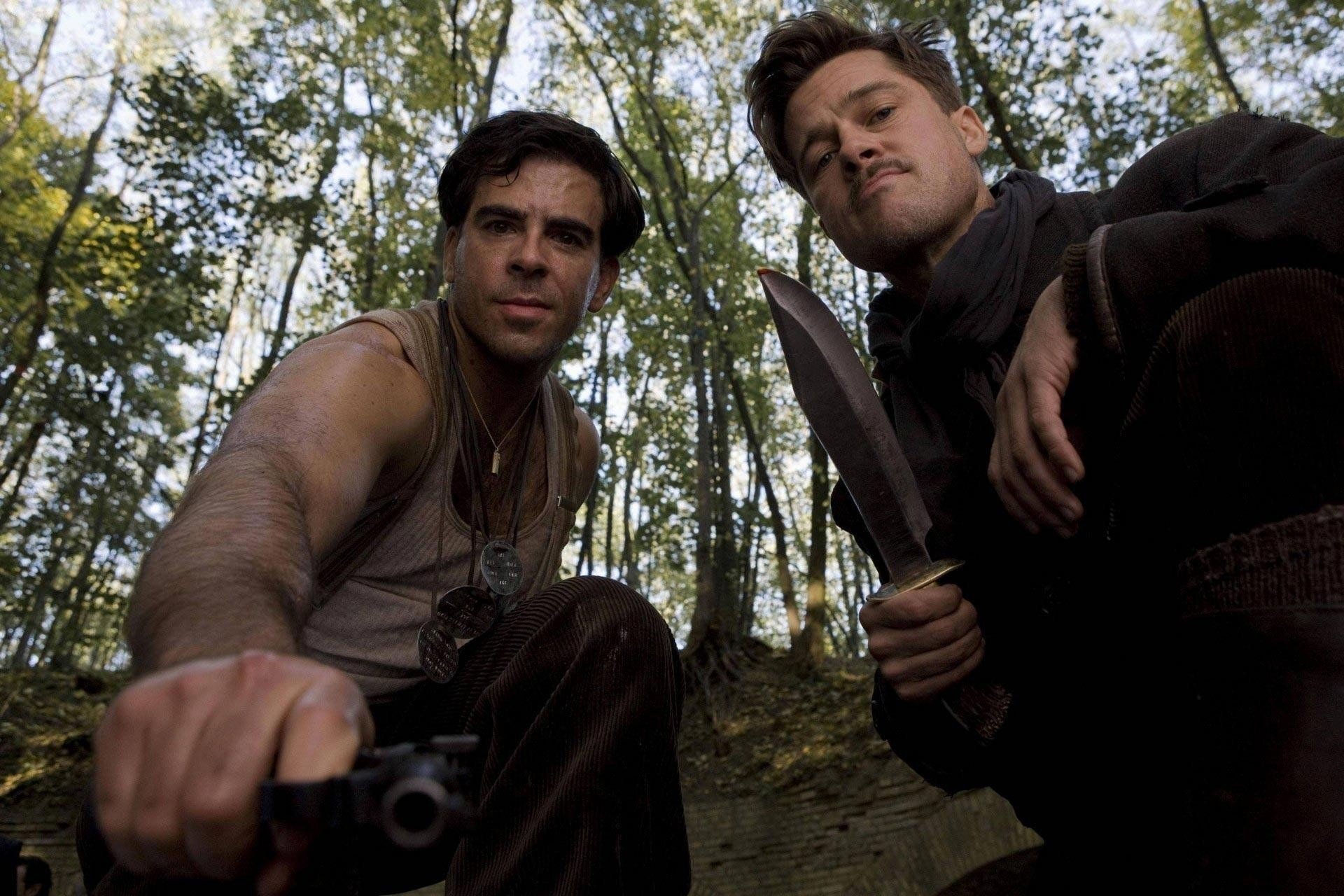 Two men in the woods holding guns