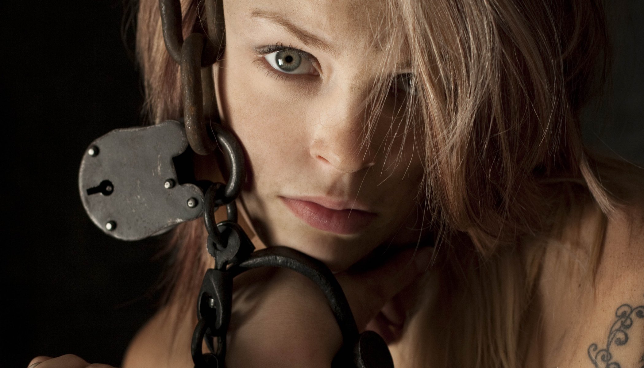 Macro photo of a girl in chains on a lock with a tattoo