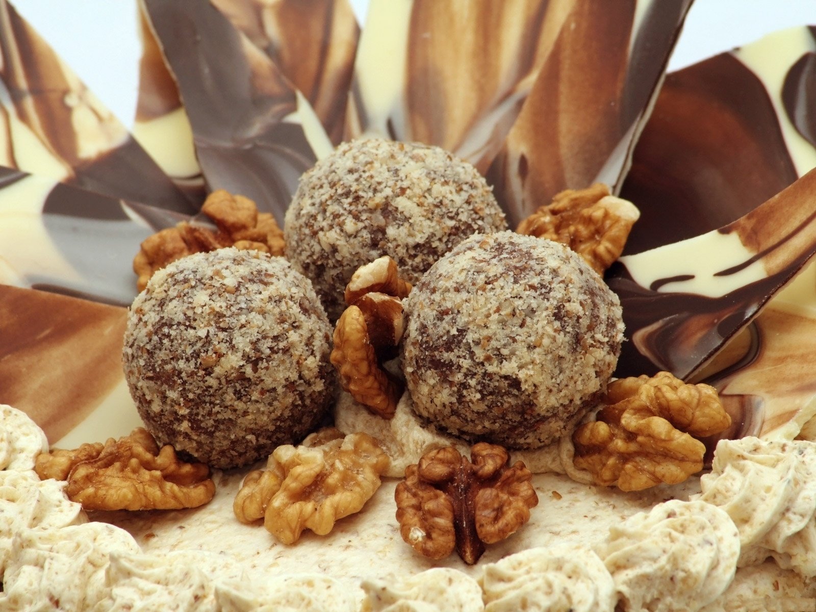 A cake sprinkled with walnuts and chocolate on top