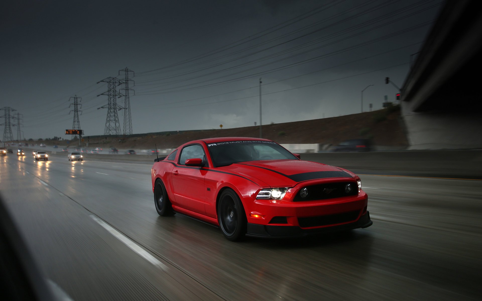 Red Ford Mustang on the road in the rain
