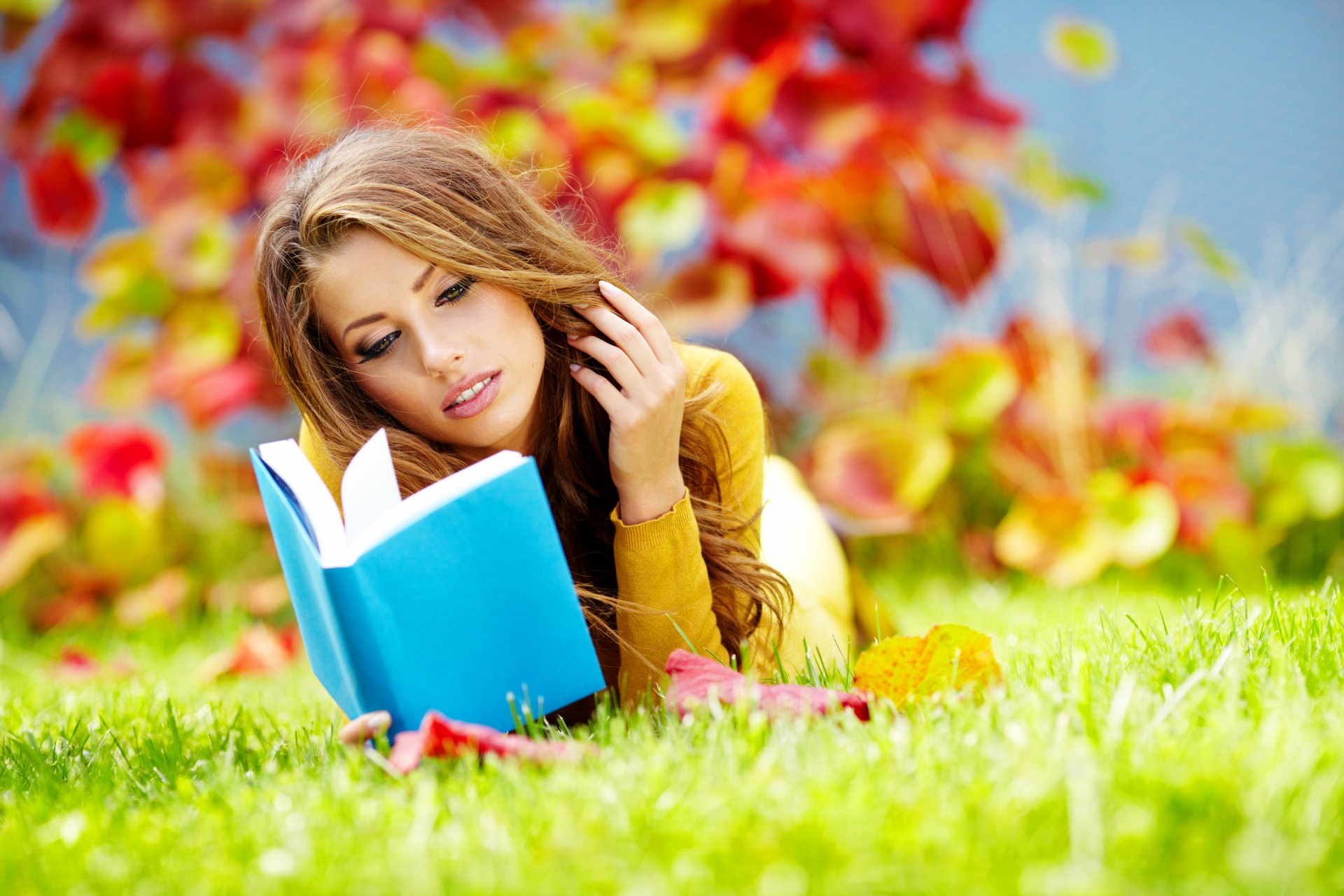 girl brown hair book park grass leaves autumn